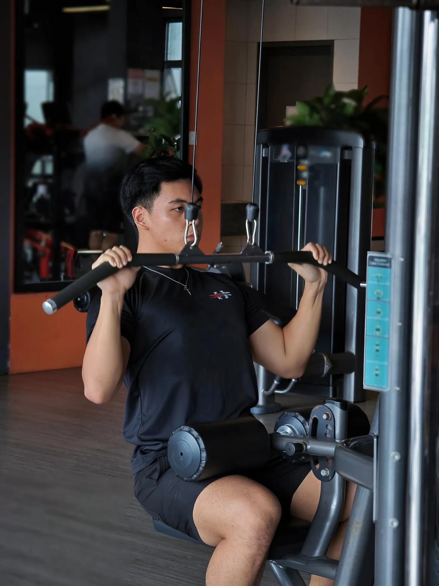 Cable pulldown on the main floor, mirrors and machines behind