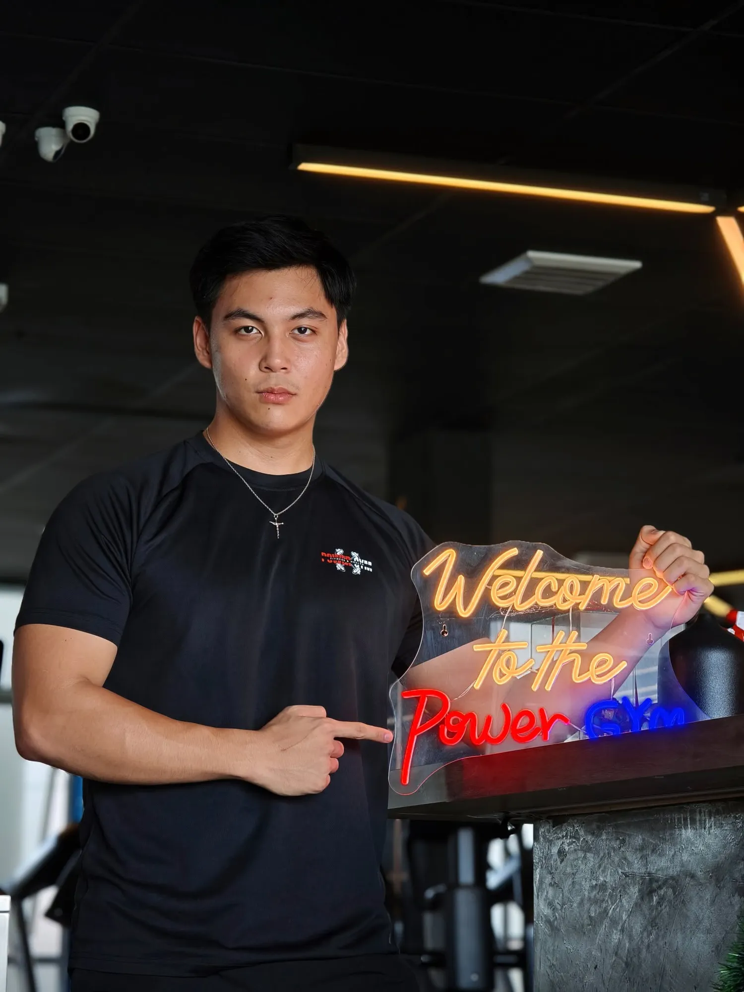 The neon "Welcome to the Power Gym" sign at the front desk